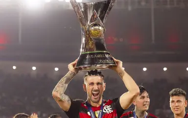 Arrascaeta tira foto com a taça do Brasileirão acima da cabeça
