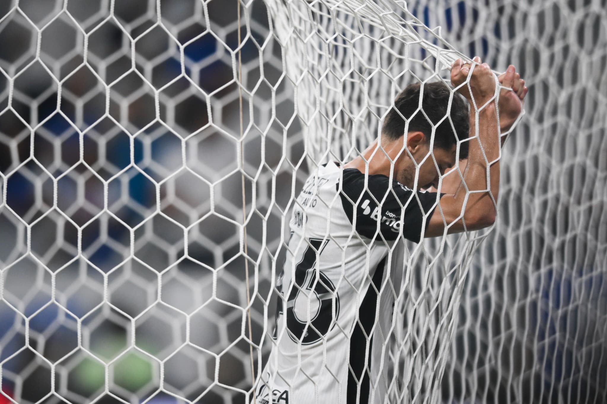 Jogador do Corinthians encostado na rede do gol durante partida no Mineirão, em postura de frustração.