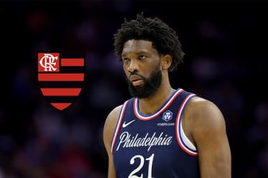 Joel Embiid do Philadelphia 76ers observa durante o segundo tempo contra o Atlanta Hawks no Xfinity Mobile Arena em 30 de novembro de 2025, na Filadélfia, Pensilvânia. Ao lado do atleta, está o escudo do Flamengo