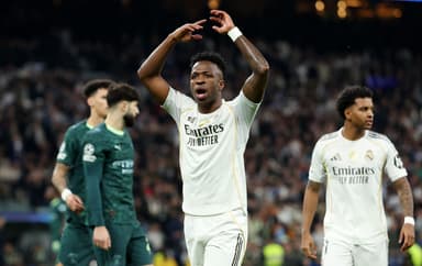 Vini Jr levanta os braços durante jogo do Real Madrid contra o Manchester City pela Champions League