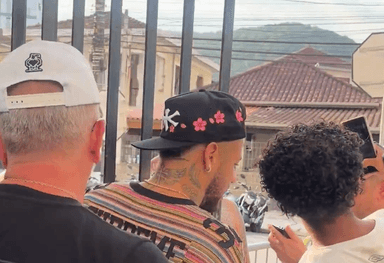 Neymar, de boné preto, conversa com torcedores na chegada à Vila Belmiro antes de jogo do Santos pelo Campeonato Paulista.