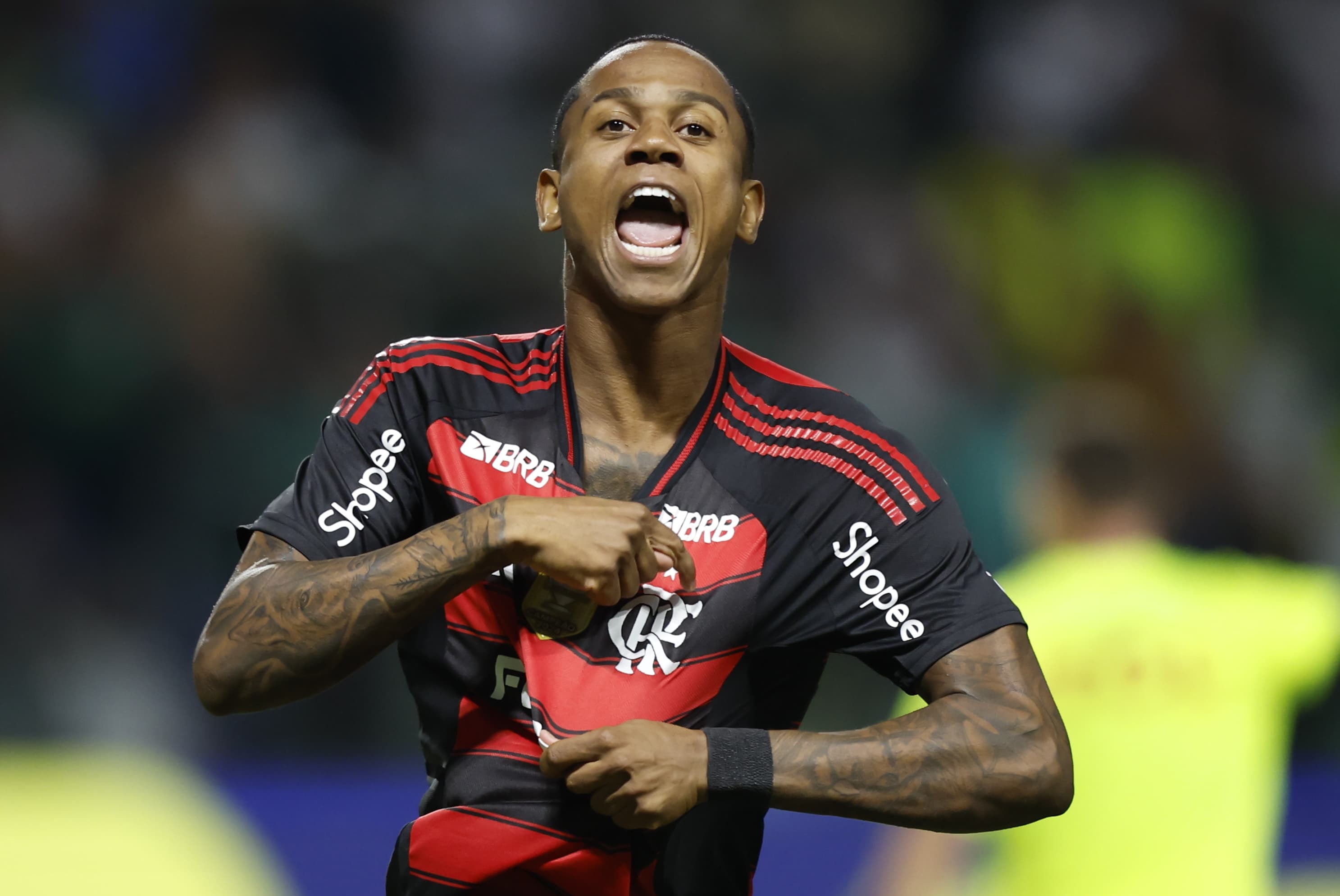 Wallace Yan comemora efusivamente mostrando escudo do Flamengo no uniforme após gol contra o Palmeiras, no Allianz Parque, pelo Brasileirão 2025