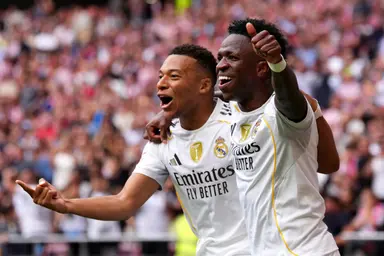 Kylian Mbappé, do Real Madrid (E), comemora o primeiro gol de sua equipe com o companheiro Vinicius Junior, também do Real Madrid (D), durante a partida da LaLiga EA Sports entre Atlético de Madrid e Real Madrid CF no Estádio Air Metropolitano de Riyadh