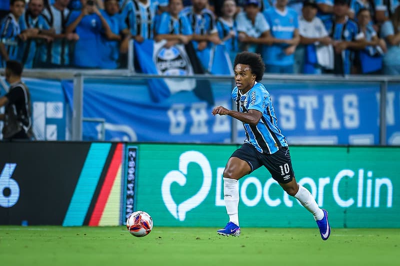 Willian, com a camisa 10 do Grêmio, corre com a bola durante o GreNal 450